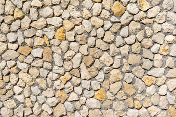 Natursteinmauer aus beigen und gelben Steinen