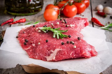 raw meat steak with rosemary and cherry tomatoes