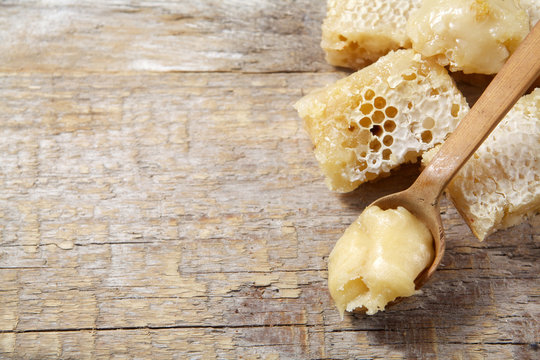 Honey with comb on wood