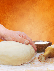 women's hands knead the dough