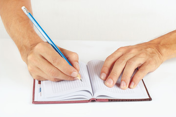 Hand written notes in pencil in a notebook on a white background