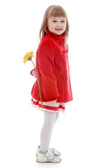 elegant little girl in a fashionable coat with a large flower be