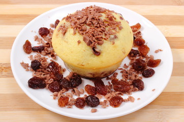 muffins with grated chocolate and heap of raisins on white plate