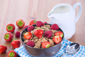 Bran flakes with fresh raspberries and strawberries and pitcher