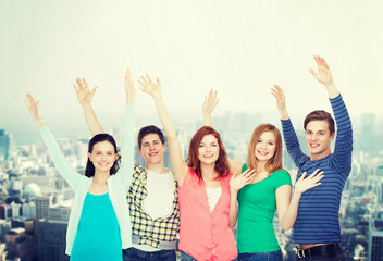 group of smiling students waving hands
