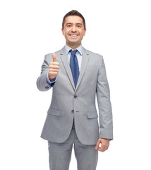 happy businessman in suit showing thumbs up