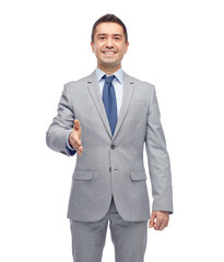 happy smiling businessman in suit shaking hand