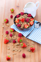 Bran flakes with fresh raspberries and strawberries and pitcher
