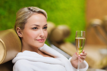 beautiful young woman drinking champagne at spa