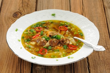 Wild mushroom and vegetable soup with chili in white plate