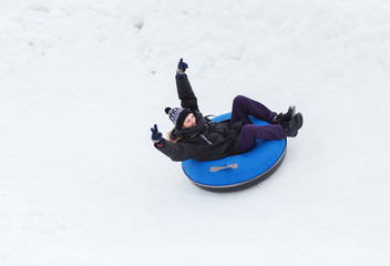 happy young man sliding down on snow tube