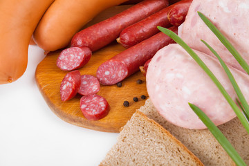 Different sorts of sausages on wooden desk and white background