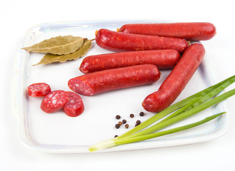 Smoked sausages on plate isolated on white background