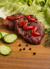 tasty grill meat with sauce and green on wooden background