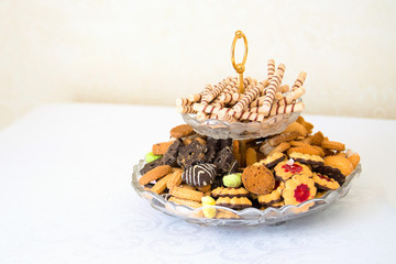 Tray with delicious cakes and macaroon on table