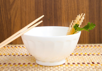 spaghetti, macaroni soup with green leaf on wooden background