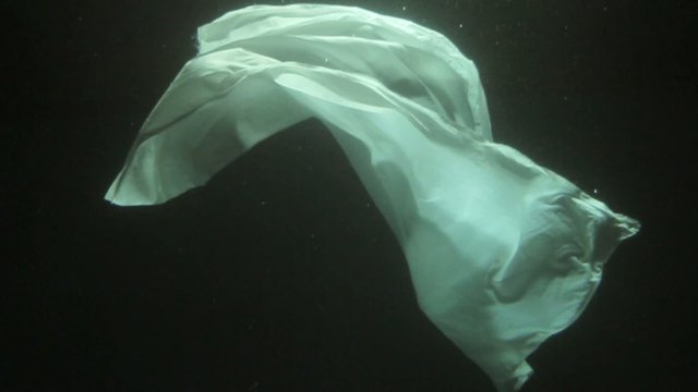 Underwater shots of White Blanket floating with dark background