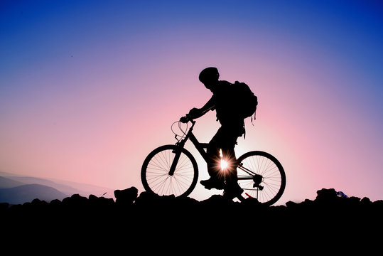 Silhouette of a man on mountain bike at sunset