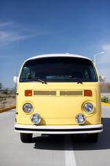 Żółty VW autobus przed niebieskim niebem - 78133609