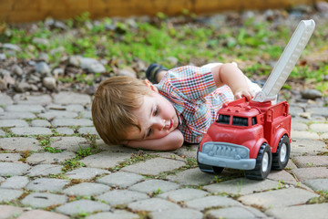 Boy Playing with a Toy Fire Truck