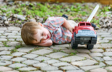Toddler Playing with a Toy Fire Truck Outside - 78135296