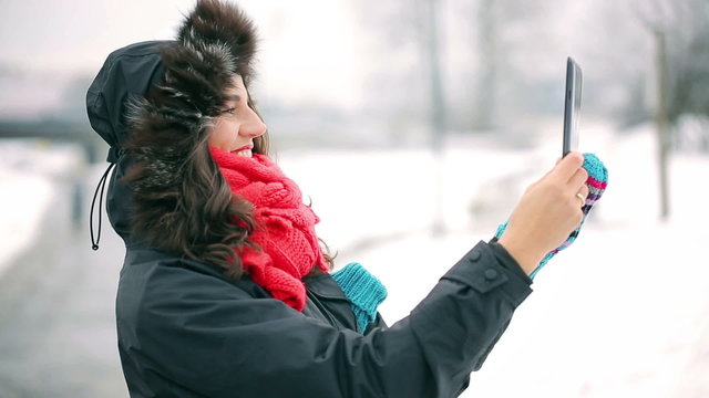 Woman recording park on tablet at winter time