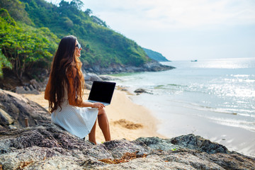 woman sitting on the rock with laptop