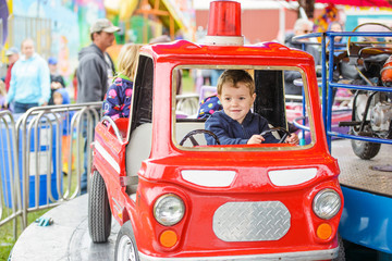 Boy Smiling on a Merry-Go-Round Firetruck - 78136899