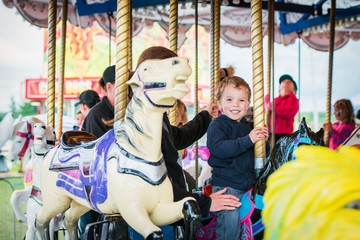 Fototapeta na wymiar Excited Boy on a Carousel Horse