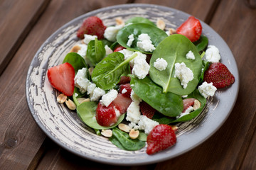 Salad with strawberries, spinach leaves and cheese, studio shot