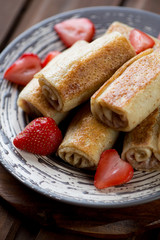 Close-up of rolled crepes with strawberries, selective focus