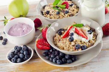 Muesli,  ripe berries and yogurt for  breakfast  on a wooden tab