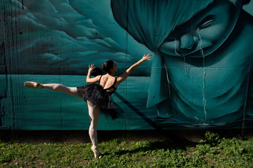Danseuse classique devant un graffiti.