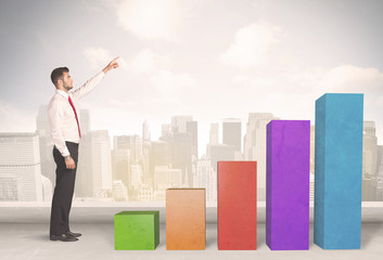 Business person climbing up on colourful chart pillars concept