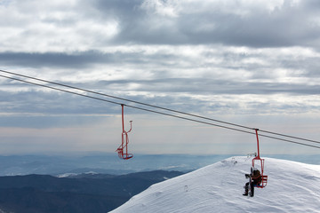 Skater resting in charilift in mountain