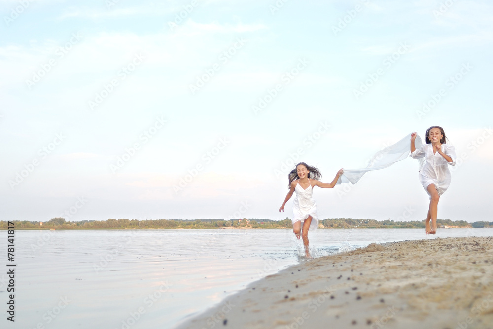 Wall mural Portrait of two girls on the beach