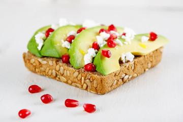Avocado with Feta, pomegranate on sunflower seeds bread sandwich
