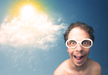 Young person looking with sunglasses at clouds and sun