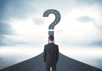 Business person lokking at road with question mark sign