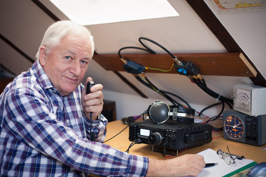 Enthusiastic middle-aged radio-amateur at his station