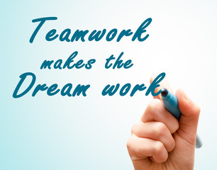 Hand with pen writing team work makes the dream work