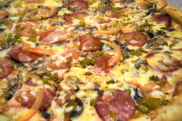 pizza with sausages, tomatoes and spinach close up view