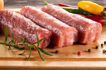 Raw pork chops on cutting board and vegetables