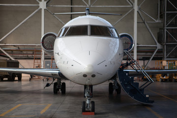 Fototapeta na wymiar Business jet airplane stays in hangar.