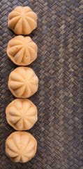 Kuih bahulu, a Malay sweet egg sponge cake on wicker mat.
