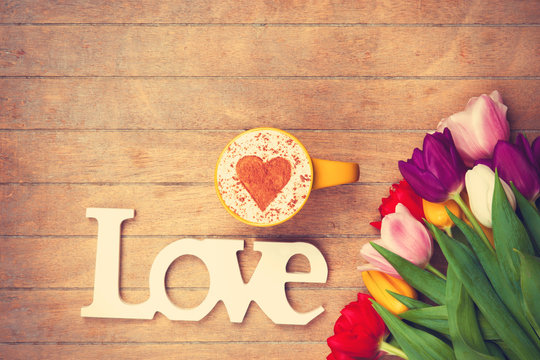 Cappuccino and word Love near flowers