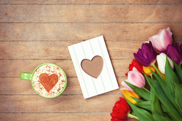 Cup and photo frame near flowers