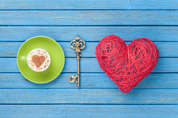 Cup of Cappuccino with heart shape symbol, key and toy