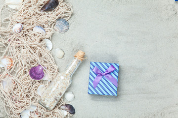 Fototapeta na wymiar Net, shells with bottle and gift box