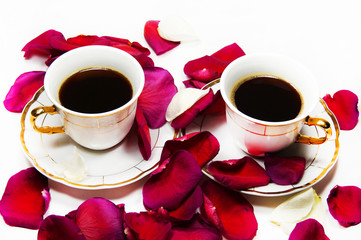 two cups of coffee in the petals of roses